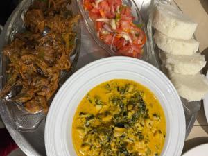 a plate of food with a bowl of soup and bread at JozaniBiospherevillage in Jozani