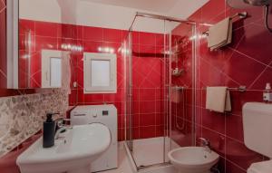 a red tiled bathroom with a sink and a toilet at Apartman Cukar Pula in Pula +18 photos