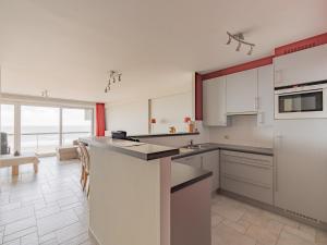 eine große Küche mit weißen Geräten und einem großen Fenster in der Unterkunft Luxury 2-bedroom apartment with stunning sea view T207 in Blankenberge + 10 Fotos