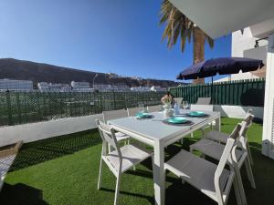 - une table blanche avec des chaises et un parasol sur la terrasse dans l'établissement Breeze Puerto Rico, à Puerto Rico