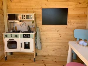 a small kitchen with a stove and a microwave at Domki u Oli in Stegna +27 photos
