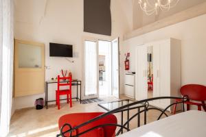 a living room with red chairs and a table at Cortile Carducci in Racale