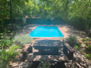 a swimming pool with a bench and a picnic table at Boutique at milner guesthouse in Bloemfontein
