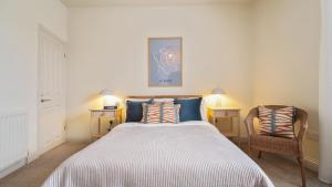 a bedroom with a large bed with two tables and a chair at Crookes Gem with Garden & Alpacas Nearby in Walkley