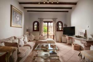 a living room with a couch and a tv at Garden Village Residence in Kalamaki