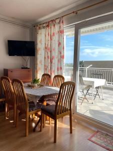 a dining room with a table and chairs and a balcony at Apartments Villa More in Makarska