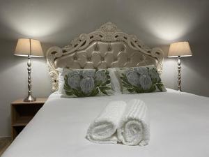 a bed with two towels on it with two lamps at Boutique at milner guesthouse in Bloemfontein +64 photos