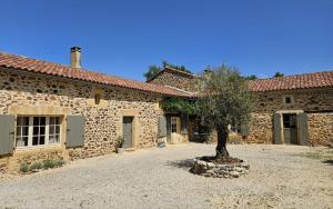 a stone building with a tree in front of it at B&B La Taupinière Rustique table d'hôtes gastronomique in Mazeyrolles