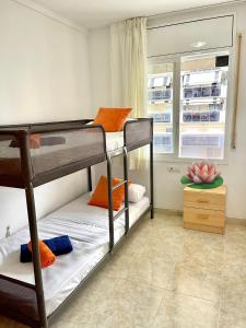 two bunk beds in a room with a window at NOVA PINEDA 2 y VISTAS PISCINA in La Pineda +28 photos