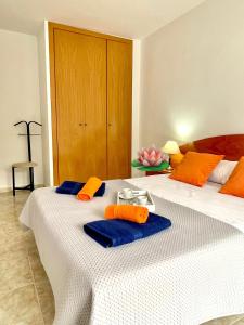 a bedroom with a bed with blue towels on it at NOVA PINEDA 2 y VISTAS PISCINA in La Pineda