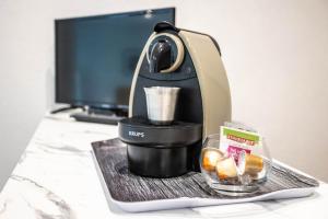 eine Kaffeemaschine auf dem Schreibtisch in der Unterkunft les Jardiniers in Straßburg