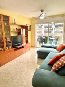 a living room with two blue couches and a television at NOVA PINEDA 2 y VISTAS PISCINA in La Pineda
