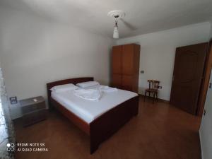 a bedroom with a bed and a table and a chair at Rina's Appartment in Çorovodë