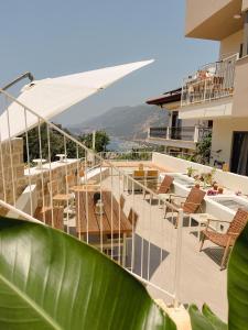 un balcón de un hotel con mesas y sillas en Katana Suites Kaş, en Kas