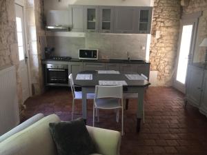 una cucina con un tavolo e sedie in una stanza di Logement Château de Villeneuve 