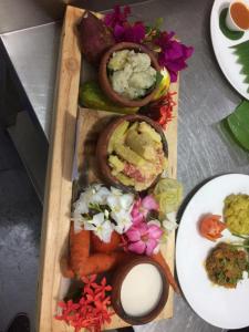 a wooden tray with different types of food on it at JozaniBiospherevillage in Jozani