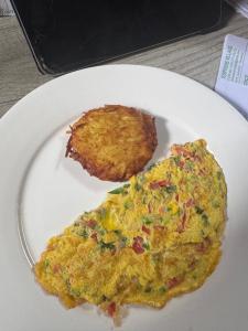 a white plate with an omelet and a piece of food at JozaniBiospherevillage in Jozani
