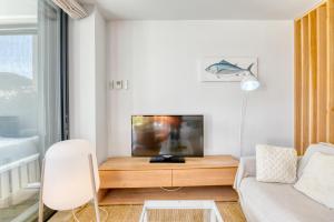 a living room with a couch and a tv on a table at Luxury Central Apartments, Illa Blanca, Calella in Calella de Palafrugell +42 photos
