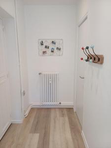 an empty room with a white door and wooden floors at Appartement reposant à Vittel in Vittel