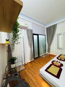 a bedroom with a large bed and some windows at Đại Nội Saphia Homestay & Villa in Hue
