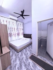 a bedroom with a bed and a ceiling fan at Bushriah Homestay Pendang in Pendang +6 photos