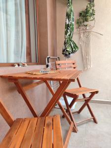 a wooden picnic table and a bench and a plant at Flat Lora Pomorie in Pomorie