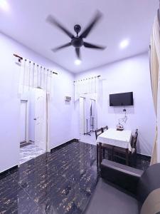 a living room with a ceiling fan and a table at Bushriah Homestay Pendang in Pendang +6 photos