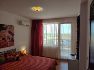 a bedroom with a bed and a large window at Flat Lora Pomorie in Pomorie