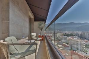 a balcony with chairs and a view of a city at Infinity Hotel & More in Budva