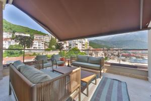 a balcony with furniture and a view of a city at Infinity Hotel & More in Budva +37 photos