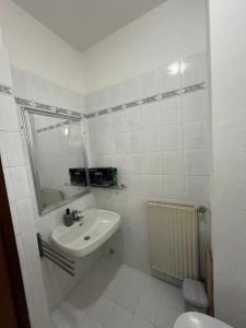 a white bathroom with a sink and a toilet at Alloggio peonia in Riva del Garda +10 photos
