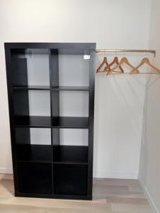 a black book shelf in a room at Grand studio centre-ville in Villedieu-les-Poëles
