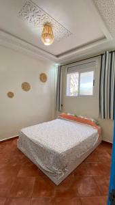 a bedroom with a bed and a window at Moroccan Family House in Agadir
