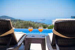 zwei Gläser Wein auf einem Tisch in der Nähe eines Pools in der Unterkunft Premium3 in Bezirgân