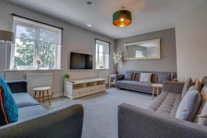 un salon avec deux canapés et une télévision dans l'établissement Spacious & Stylish 5BR Townhouse - Free Parking, à Manor