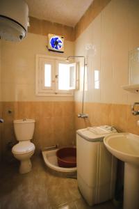 a bathroom with a toilet and a sink and a tub at برج اللوتس 2 شقق فندقية مكيفة للايجار in Marsa Matruh
