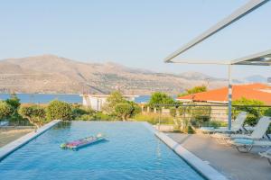 a swimming pool with a raft in the water at Villa Amantia in Kouvaláta