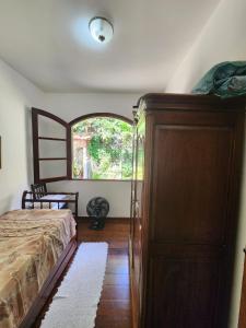 a bedroom with a bed and a large window at #Hospedagem Nota 10 de Teresópolis in Teresópolis