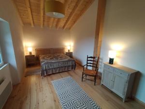 a bedroom with a bed and a chair and a table at Maison basque de charme avec piscine in Souraïde