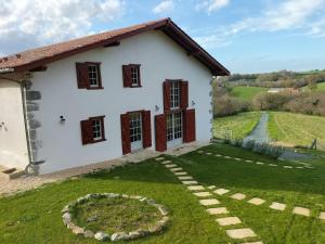 a small white house with a garden in front of it at Maison basque de charme avec piscine in Souraïde