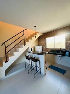 a kitchen with a staircase and a counter with stools at Nosso Chalé in Serra de São Bento