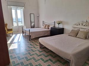 ein Schlafzimmer mit zwei Betten und einem Fenster in der Unterkunft Casa vacanze San Martino in Irsina