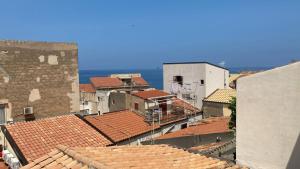 a view of roofs of buildings and the ocean at La vista al di sopra dei tetti in Cefalù