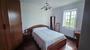 ein Schlafzimmer mit einem Bett und einem Fenster in der Unterkunft Casa con encanto amplios jardines al lado de la playa in Caleiro