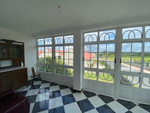 Zimmer mit großen Fenstern und Blick auf ein Gebäude in der Unterkunft Casa con encanto amplios jardines al lado de la playa in Caleiro
