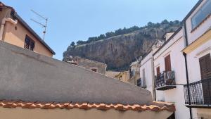 an alley with buildings and a mountain in the background at La vista al di sopra dei tetti in Cefalù