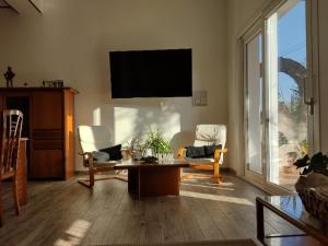 a living room with a tv and a table and chairs at Il Ginepro del Campidano in Nuraminis