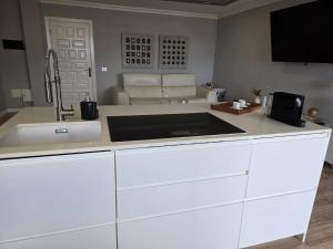 a white kitchen with a sink and a couch at C&C Suites in Los Llanos de Aridane