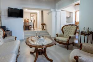 a living room with a coffee table and chairs at Terra Nobile, 3BR Mountain Stone Escape BBQ Fireplace in Galataria