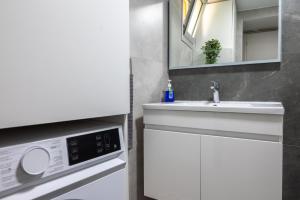 a bathroom with a sink and a washing machine at Terra Nobile, 3BR Mountain Stone Escape BBQ Fireplace in Galataria +50 photos